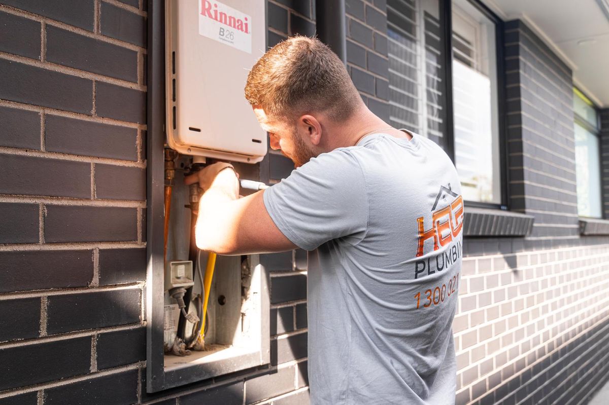 Help Plumbing tradesman working on a hot water unit in a Sydney home